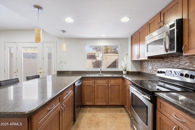 kitchen featuring sink, hanging light fixtures, kitchen peninsula, and appliances with stainless steel finishes