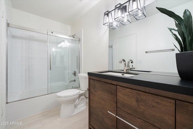 full bathroom with vanity, shower / bath combination with glass door, and toilet