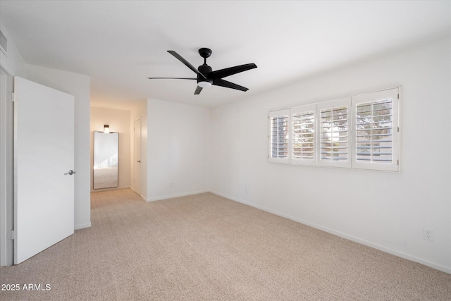 unfurnished room with ceiling fan and light carpet