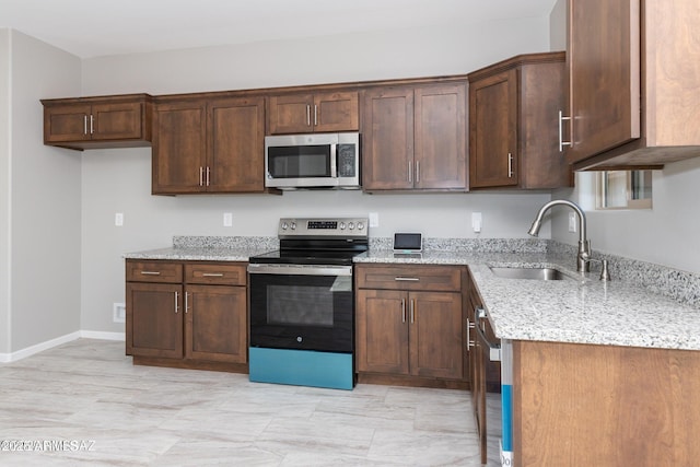 19 E Elm St, Tucson, AZ 85705 - kitchen with appliances with stainless steel finishes, a sink, light stone counters, and baseboards