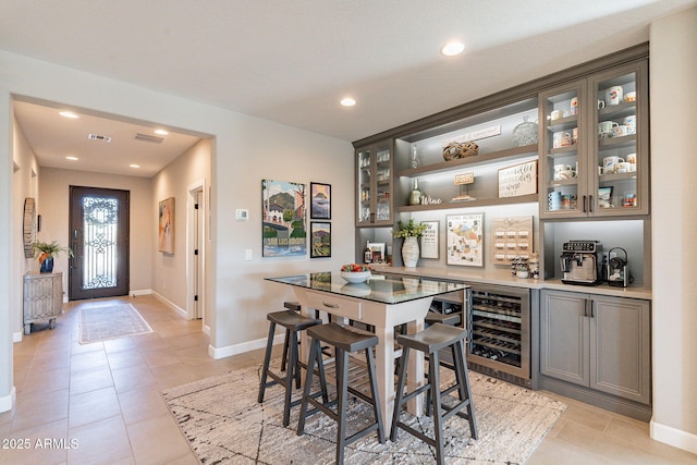 bar with beverage cooler and light tile patterned flooring