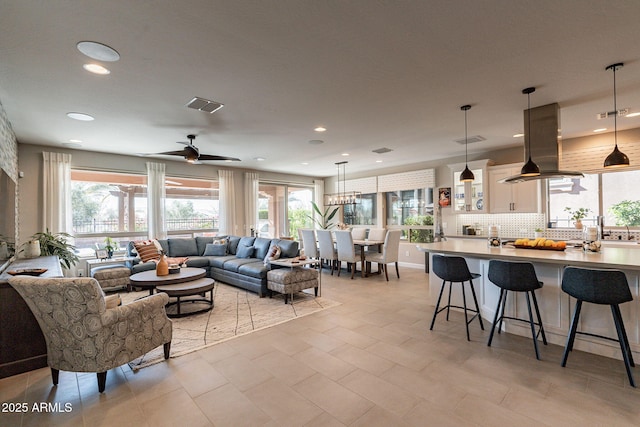 living room featuring ceiling fan and a healthy amount of sunlight