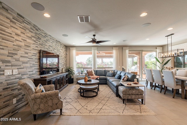 living room with ceiling fan with notable chandelier