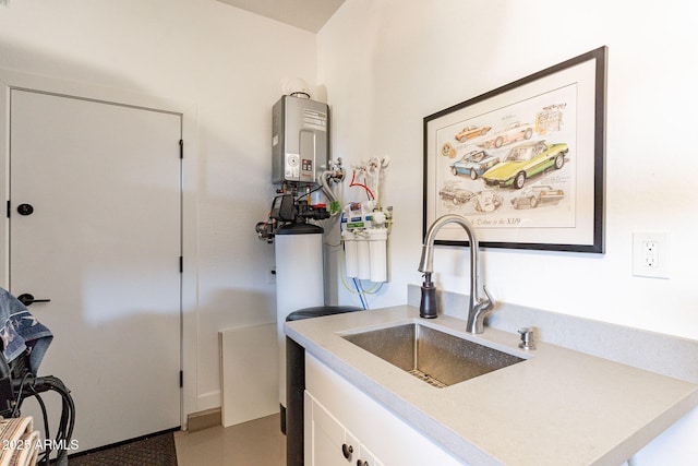 kitchen featuring white cabinetry, sink, and tankless water heater