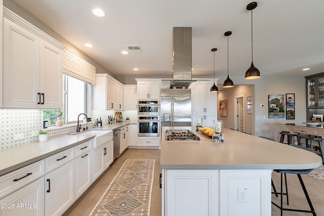 kitchen with pendant lighting, a center island, white cabinets, and appliances with stainless steel finishes