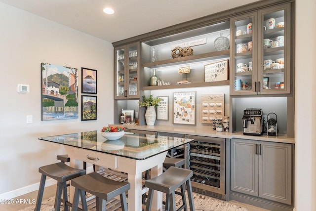 bar featuring dark stone countertops and beverage cooler