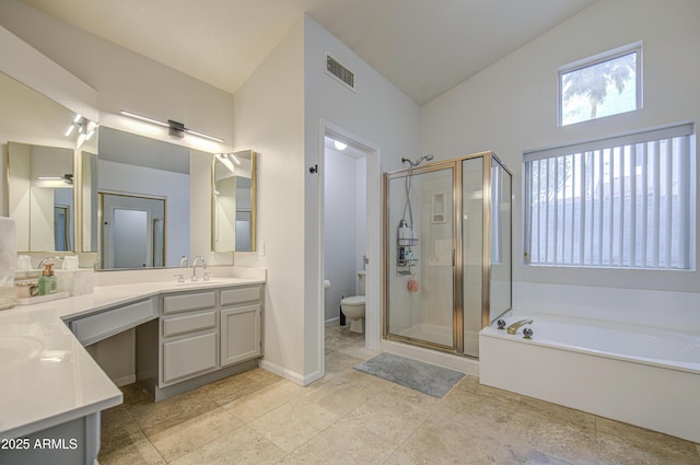 bathroom featuring vanity, toilet, visible vents, a bath, and a stall shower