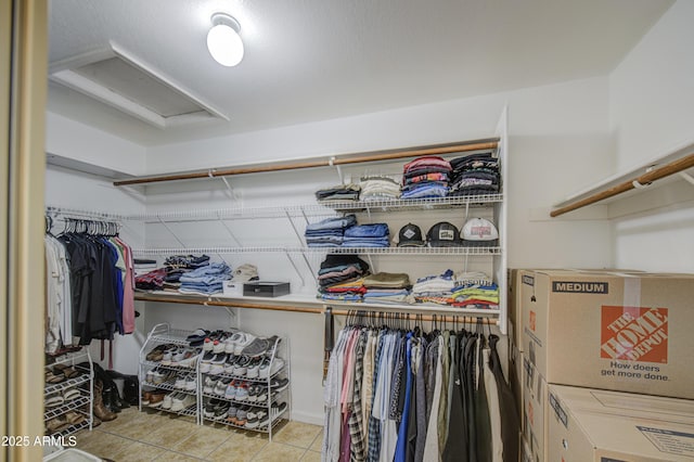 spacious closet with tile patterned floors and attic access