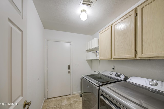 washroom with a textured ceiling, independent washer and dryer, visible vents, cabinet space, and baseboards
