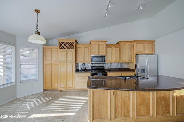 kitchen featuring light brown cabinetry, an island with sink, rail lighting, a sink, and stainless steel appliances