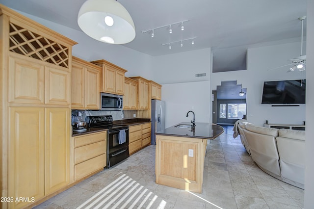 kitchen featuring visible vents, dark countertops, a sink, light brown cabinets, and stainless steel appliances