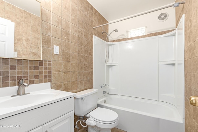 full bathroom featuring tile walls, vanity, bathtub / shower combination, and toilet