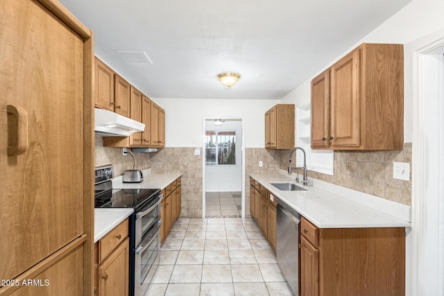 kitchen with sink, backsplash, light tile patterned floors, and appliances with stainless steel finishes