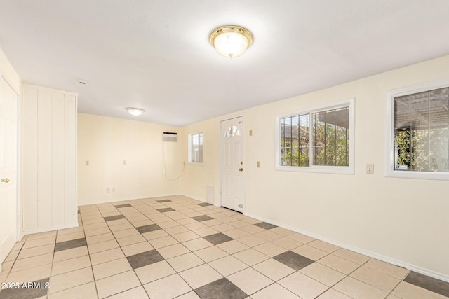 spare room with light tile patterned floors and a wall mounted AC