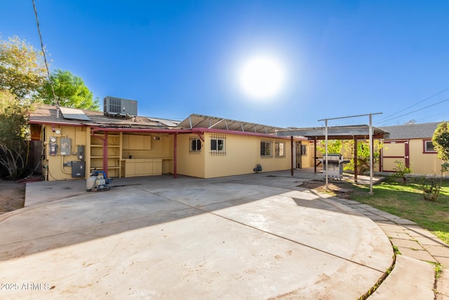 back of house featuring a patio, solar panels, and central air condition unit