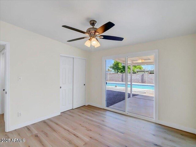 3650 E Laurel Ln, Phoenix, AZ 85028 - unfurnished bedroom featuring access to exterior, light wood finished floors, baseboards, and a closet
