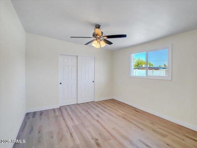 3650 E Laurel Ln, Phoenix, AZ 85028 - unfurnished bedroom with wood finished floors, a closet, baseboards, and a ceiling fan