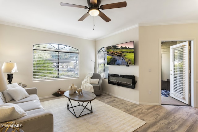 living room featuring wood-type flooring, a wealth of natural light, ornamental molding, and ceiling fan