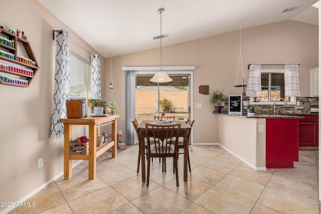 dining area with a healthy amount of sunlight, visible vents, and vaulted ceiling