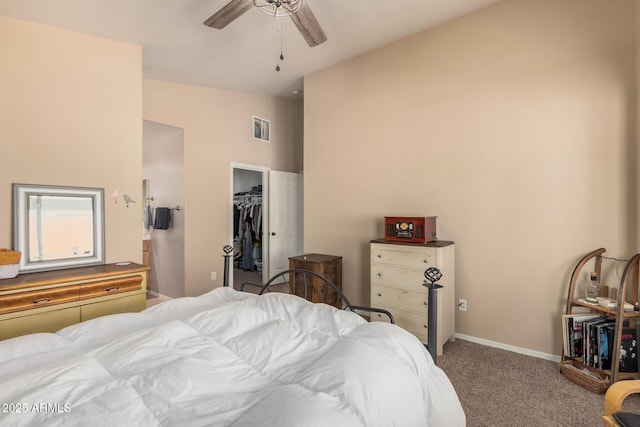 bedroom featuring carpet, visible vents, a spacious closet, vaulted ceiling, and baseboards