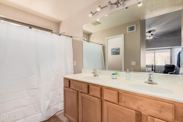 ensuite bathroom featuring double vanity, a sink, and visible vents