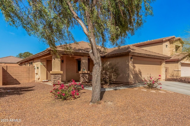 single story home featuring concrete driveway, an attached garage, fence, and stucco siding