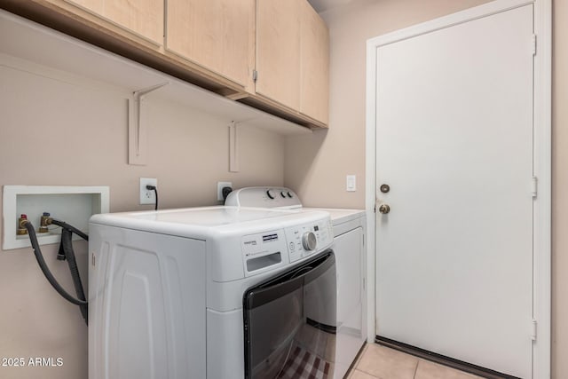 laundry area featuring cabinet space, washer and clothes dryer, and light tile patterned floors