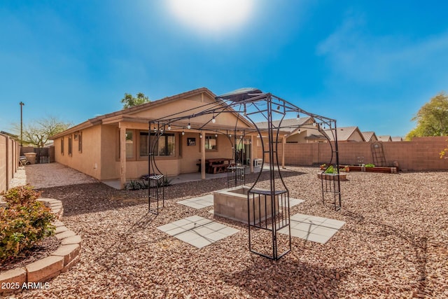 back of house with a patio area, a fenced backyard, and stucco siding