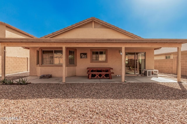 rear view of house with fence, a patio, and stucco siding