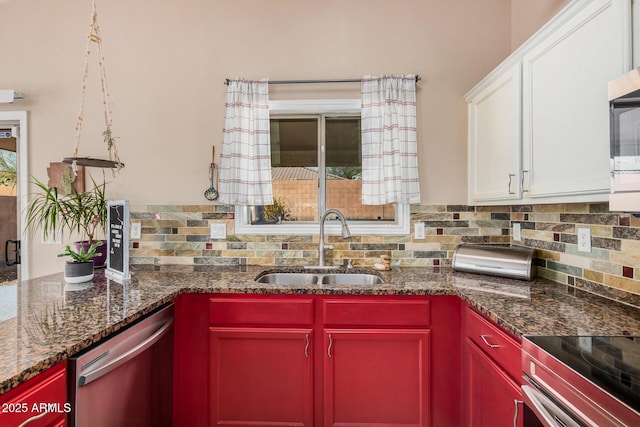 kitchen with white cabinetry, appliances with stainless steel finishes, backsplash, and a sink