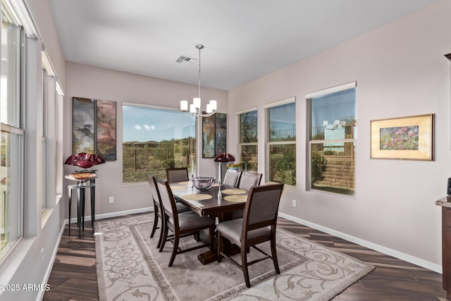 dining space with an inviting chandelier, wood finished floors, baseboards, and visible vents