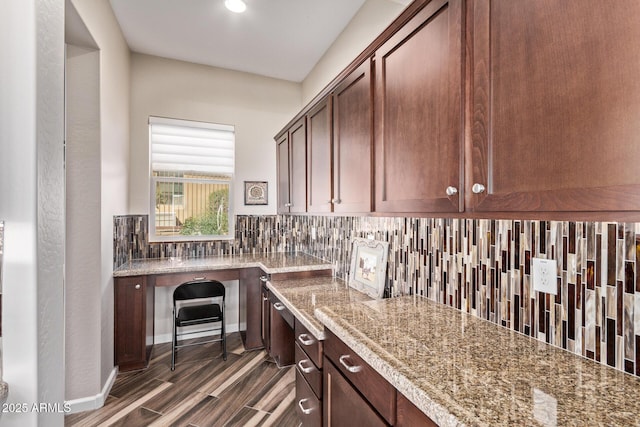 bar featuring dark wood-style floors, backsplash, and baseboards