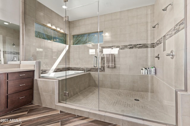 bathroom featuring visible vents, vanity, a bath, and a shower stall