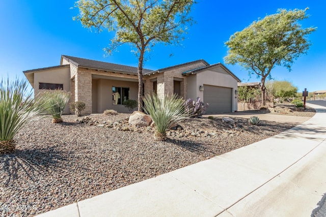 ranch-style house featuring stucco siding, stone siding, driveway, and an attached garage