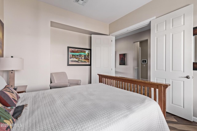 bedroom with dark wood finished floors and visible vents