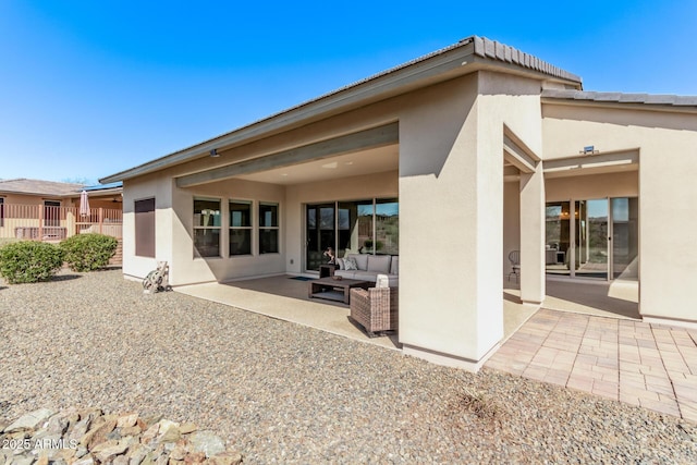 back of house featuring outdoor lounge area, a patio area, and stucco siding