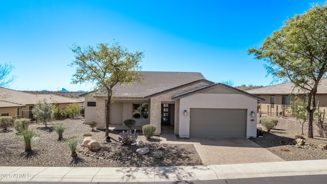 view of front of property with stucco siding, a tiled roof, decorative driveway, and a garage