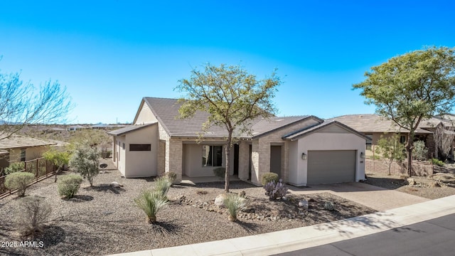 view of front of property featuring fence, a garage, driveway, and stucco siding