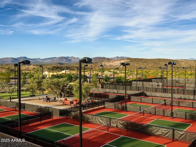 view of sport court with a mountain view and fence