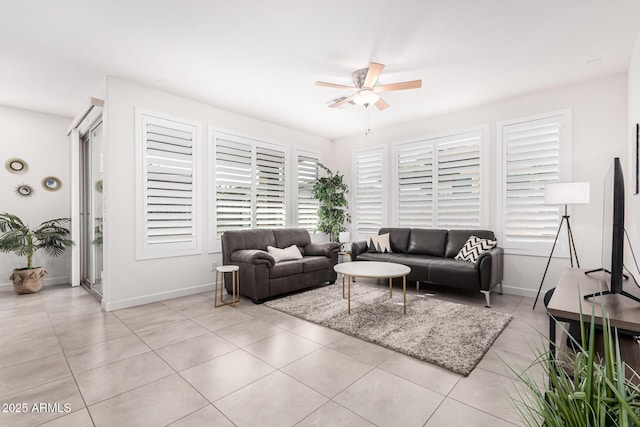 living room with ceiling fan, plenty of natural light, and light tile patterned floors