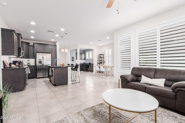 tiled living room with sink and ceiling fan