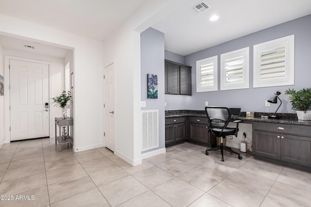 office space with built in desk and light tile patterned flooring