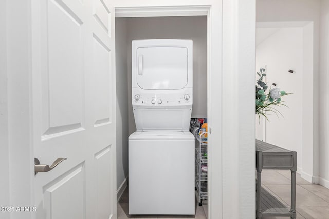 laundry area featuring stacked washer and clothes dryer and light tile patterned floors