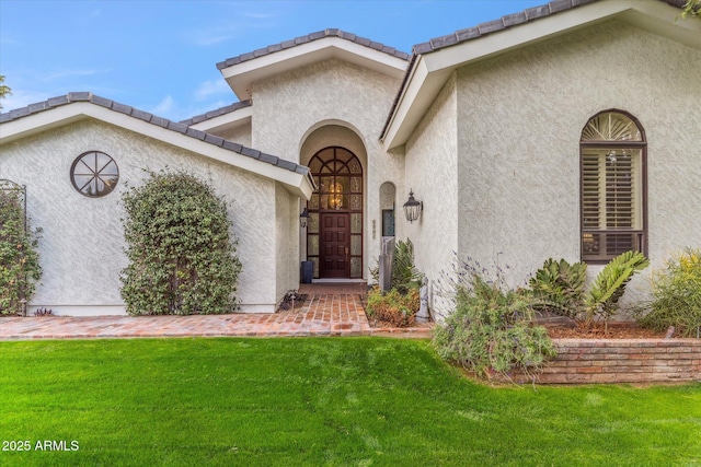 property entrance with a lawn