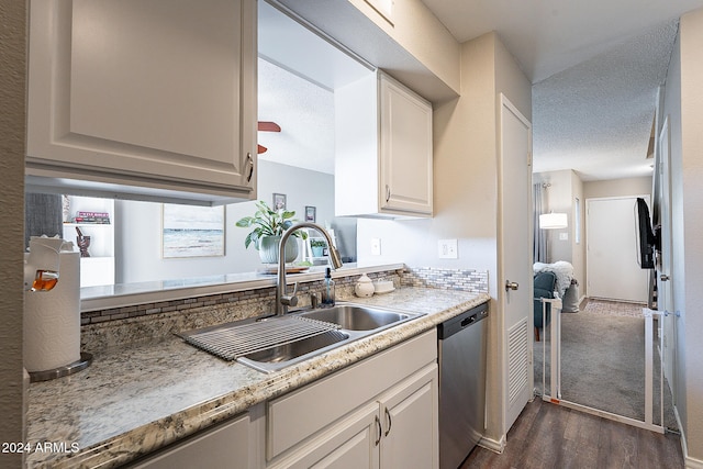 kitchen with white cabinets, a textured ceiling, dishwasher, dark wood-type flooring, and sink