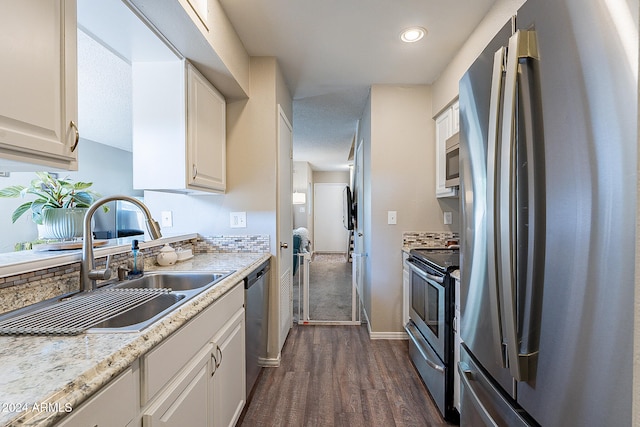 kitchen with appliances with stainless steel finishes, sink, dark hardwood / wood-style floors, and white cabinets