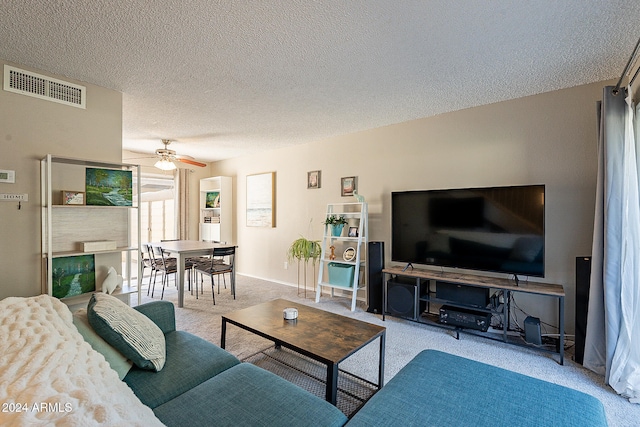 living room featuring light carpet, a textured ceiling, and ceiling fan