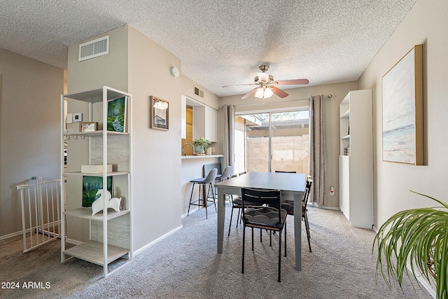 carpeted dining space with a textured ceiling and ceiling fan