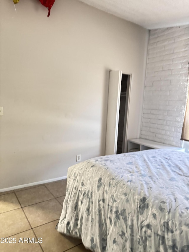 bedroom with baseboards and tile patterned flooring