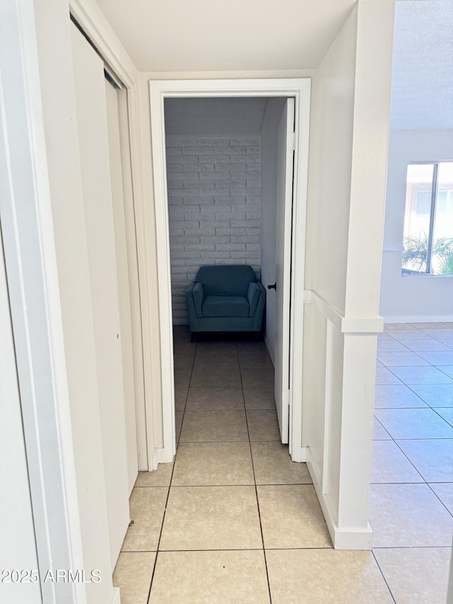 hallway featuring light tile patterned floors and baseboards